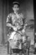 Malaysia / Singapore: Formal portrait of a Nyonya woman posing in a studio, early 20th century