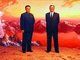 Korea: North Korean (DPRK) propaganda poster showing Kim Il Sung (in business suit) together with Kim Jong Il (in Mao suit) both beaming atop a mountain range